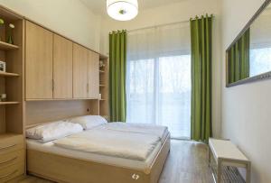 オストゼーバート・ディアーハーゲンにあるDUENENROSE App Nr 03 max 3 Persのベッドルーム1室(ベッド1台付)、窓(緑のカーテン付)
