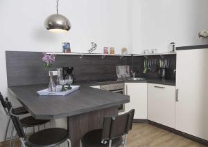 una cocina con encimera y algunas sillas. en DUENENROSE App Nr 03 max 3 Pers, en Dierhagen