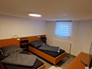 una piccola camera con due letti e una finestra di Monteurzimmer-mit GemeinschaftsBad und Küche BEI RASTATT a Muggensturm