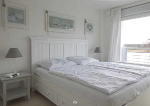 オストゼーバート・ディアーハーゲンにあるSONNENDECK App Nr 19 max 4 Persの白いベッドルーム(大型ベッド1台、窓付)