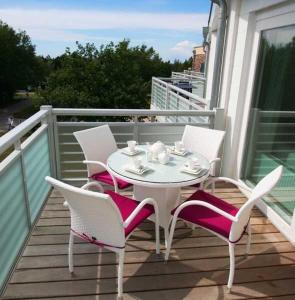 - Balcón con mesa blanca y sillas en SONNENDECK App Nr 19 max 4 Pers, en Dierhagen