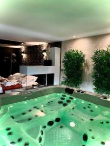 La Charmeuse (Suite privée pour amoureux في Belin-Beliet: حوض استحمام كبير أخضر في الغرفة