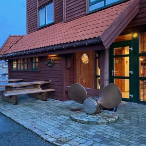 un edificio con un banco y una mesa delante de él en Sirevåg Konferansehotell AS en Sirevåg