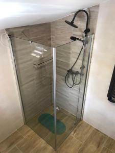 a shower with a glass door in a bathroom at Domek Damianki - cały dom in Zawoja