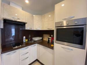 cocina con armarios blancos y microondas negro en Cosy Triangle D Or Bourgogne - By AppartAli, en Casablanca