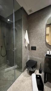 a bathroom with a shower and a black toilet at Royal Suite by the Ocean - By Appartali in Casablanca