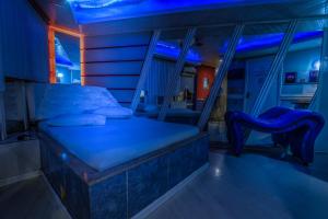 una camera con letto e illuminazione blu di Motel Kaskata a Santa Cruz do Sul