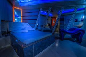a bedroom with a bed and a blue lighting at Motel Kaskata in Santa Cruz do Sul
