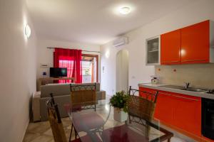 a kitchen and dining room with a glass table at Residenze Il Girasole in Golfo Aranci