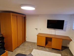 Zimmer mit einem Flachbild-TV an der Wand in der Unterkunft Monteurzimmer-mit GemeinschaftsBad und Küche BEI RASTATT in Muggensturm