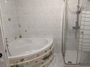 a bathroom with a tub and a shower at Ferienwohnung Ela in Bexbach