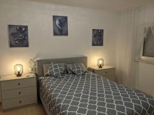 a bedroom with a bed and two night stands with lights at Ferienwohnung Ela in Bexbach