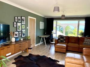 a living room with a couch and a table at Beautifully presented holiday home near the beach in Churston Ferrers