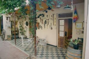 um quarto com uma mesa e cadeiras e uma árvore em El Alero Hospedaje em Mendoza