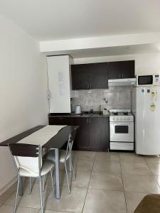 a kitchen with a table and a white refrigerator at Temporarios Sanatorios CENTRO in Rosario