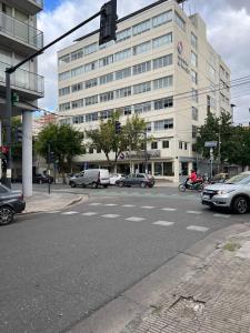 a street with cars parked in front of a building at Temporarios Sanatorios CENTRO in Rosario