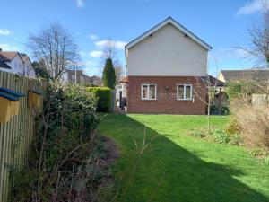 une maison avec une clôture et une cour d'herbe dans l'établissement Grange Croft, à Ben Rhydding