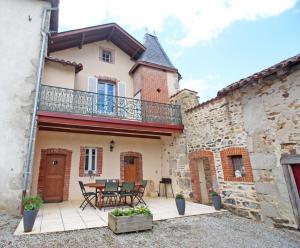 een huis met een patio met een tafel en een balkon bij Les 3 tilleuls in Bellac