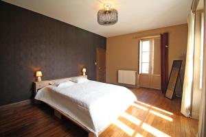 een slaapkamer met een groot wit bed en een raam bij Les 3 tilleuls in Bellac