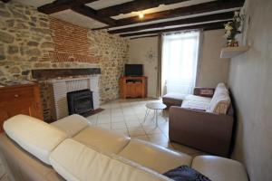 - un salon avec un canapé et une cheminée dans l'établissement Les 3 tilleuls, à Bellac