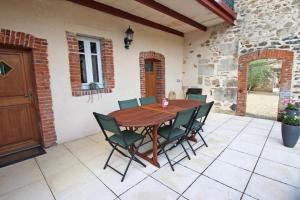 Une table et des chaises en bois sont disponibles sur la terrasse. dans l'établissement Les 3 tilleuls, à Bellac