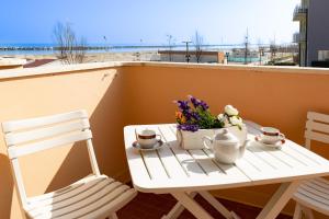 a white table and chairs on a balcony with flowers at Residence Rainbow in Bellaria-Igea Marina