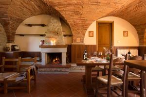 a dining room with a fireplace and a table and chairs at Buccia Nera in Chiassa Superiore