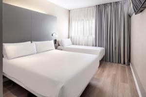 Cama blanca en habitación con ventana en B&B HOTEL Barcelona Mollet en Mollet del Vallès