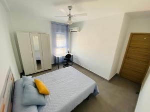 a bedroom with a bed and a couch and a window at Apartamento ZAPILLO IRIA 1 in Almería