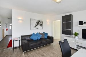 uma sala de estar com um sofá de couro preto e uma televisão em Domicilio Azzurro em Lindau