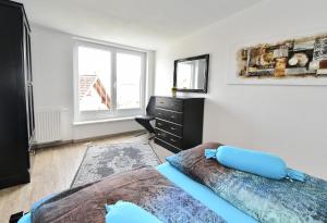 ein Schlafzimmer mit einem Bett, einer Kommode und einem Fenster in der Unterkunft Domicilio Azzurro in Lindau