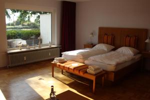 a bedroom with two beds and a table with towels at Hotel zur Treene in Schwabstedt