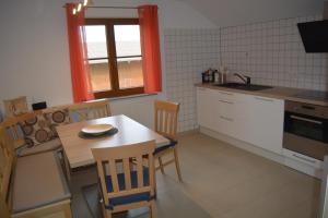 a kitchen with a table and chairs and a kitchen with a sink at Ferienwohnung Rißblick 