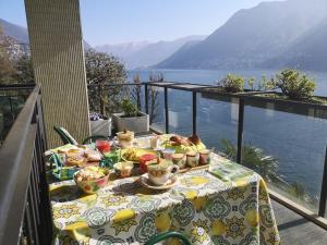 una mesa con comida en el balcón con vistas al agua en Lakeviewcabin - King Room With Balcony en Como