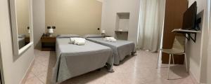 a bedroom with two beds with towels on them at Hotel Cumilì in Capo di Ponte