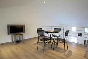 Una habitación con una mesa y sillas y un televisor. en La guinandie, en Vayres