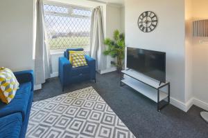 a living room with a blue couch and a television at Host & Stay - Armitage Road in Redcar