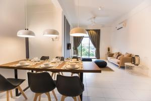 ein Esszimmer und ein Wohnzimmer mit Tisch und Stühlen in der Unterkunft ALOR SETAR IMPERIO PROFESSIONAL SUITE by Zenith Smart in Alor Setar