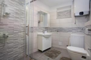 a bathroom with a toilet and a sink and a shower at Serious Job Apartment in Dubrovnik +18 photos