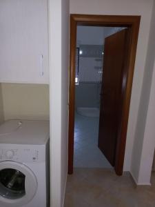 ヴロラにあるLungomare Apartament Sea view KORALのバスルーム(洗濯機付)へのドア