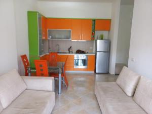 ヴロラにあるLungomare Apartament Sea view KORALのリビングルーム(ソファ、テーブル付)、キッチンが備わります。