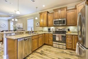 a kitchen with wooden cabinets and stainless steel appliances at Diamondhead Condo - Marina, Pool Access and Golfing! in Diamondhead