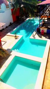 a large blue swimming pool next to a building at Hotel Chuburna in Chuburná