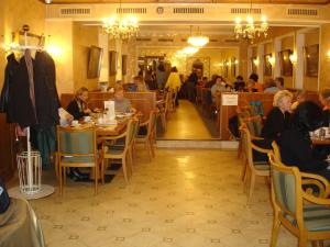 a group of people sitting at tables in a restaurant at Hotel Graupner in Bamberg