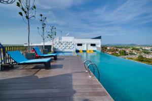 a pool on the roof of a house with blue chairs at ALOR SETAR IMPERIO PROFESSIONAL SUITE by Zenith Smart in Alor Setar