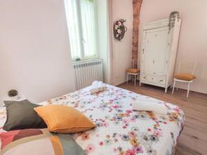 una camera da letto con un grande letto con fiori di Delizioso trilocale in centro a due passi dal mare a Grottammare