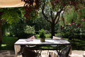 una mesa y sillas en un jardín con un árbol en Buccia Nera, en Chiassa Superiore