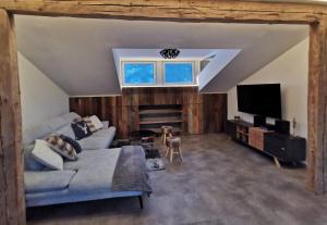 sala de estar con sofá y TV en Panorama Lodge Edelweiss en Gosau