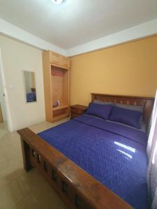 ein Schlafzimmer mit einem großen Bett mit blauer Bettwäsche in der Unterkunft Lovely 2 Bedroom Apartment with shared pool in Roseau + 28 Fotos