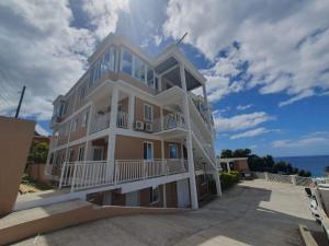 ein großes weißes Gebäude mit Balkonen in der Unterkunft Lovely 2 Bedroom Apartment with shared pool in Roseau